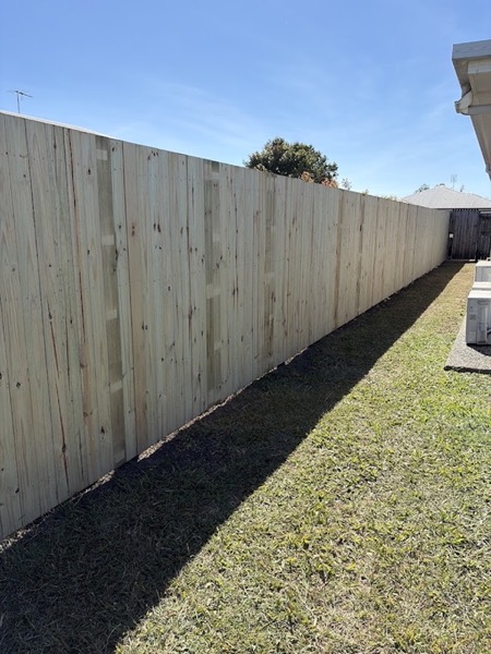 A long new timber paling fence beside a mown lawn