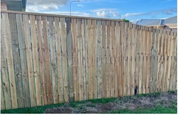 A new timber paling fence line under a Queensland sky