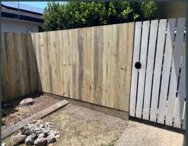 A new timber fence section built alongside an older painted fence