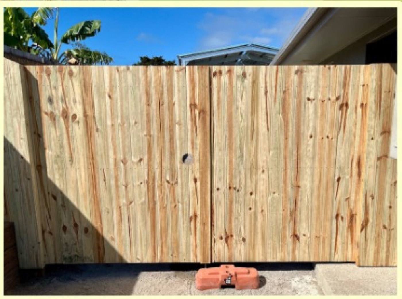 A timber double gate across a residential driveway
