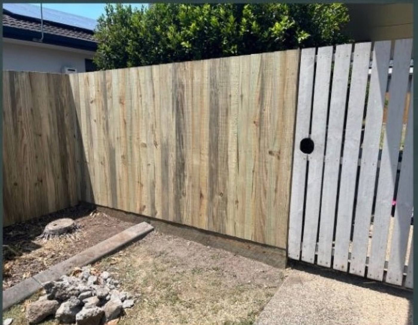 A new timber fence section built alongside an older painted fence